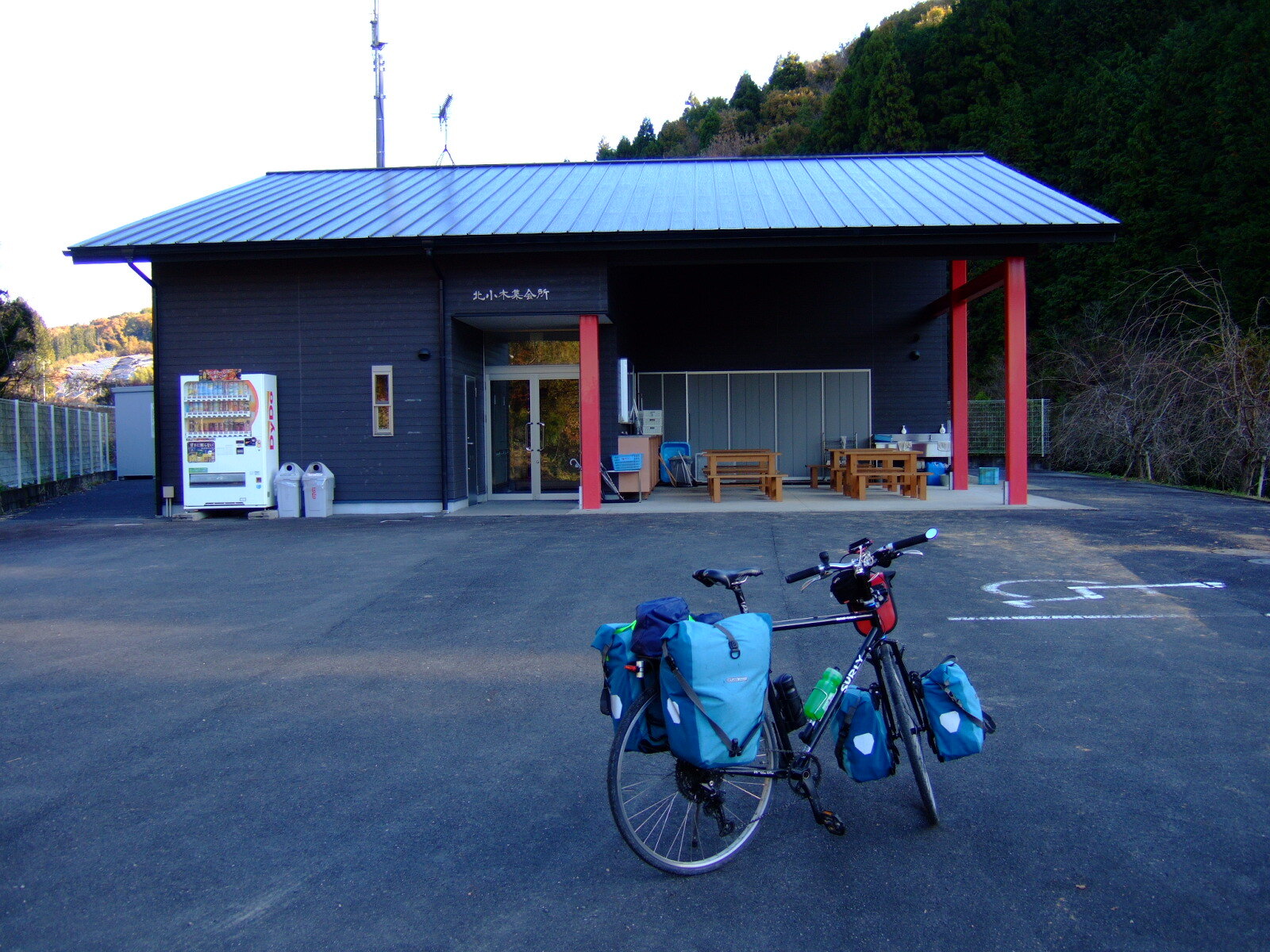 A modern building bearing a sign reading “Kitaogi Meeting Place” (北小木集会所)