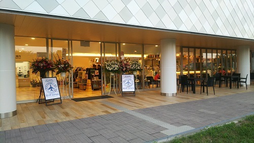 The glassed-in entrance to a coffee shop, with outdoor seating.