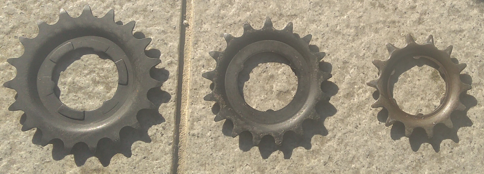 Three sprockets lined up on a tile background. From left to right the sizes are: 19-teeth; 17-teeth; and 14-teeth.